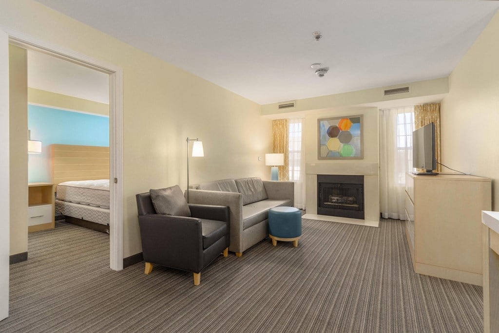 a living room with a couch and a fireplace in a hotel room